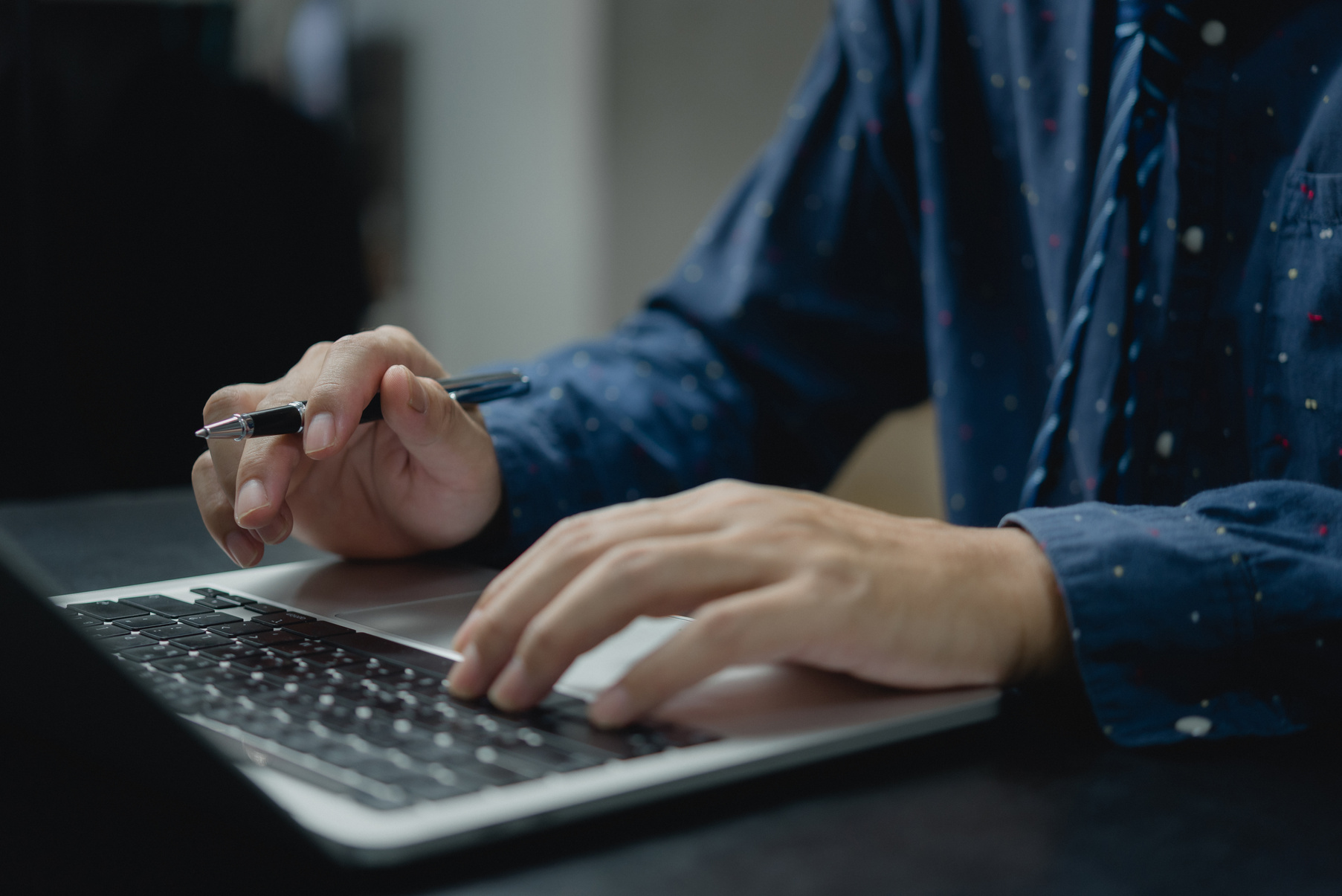 Man using computer laptop working internet searching social media and communications digital technology online at desk.